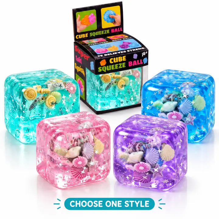 Turquoise, blue, pink and purple Ocean Cube squeeze toys with shell and star decorations beside packaging