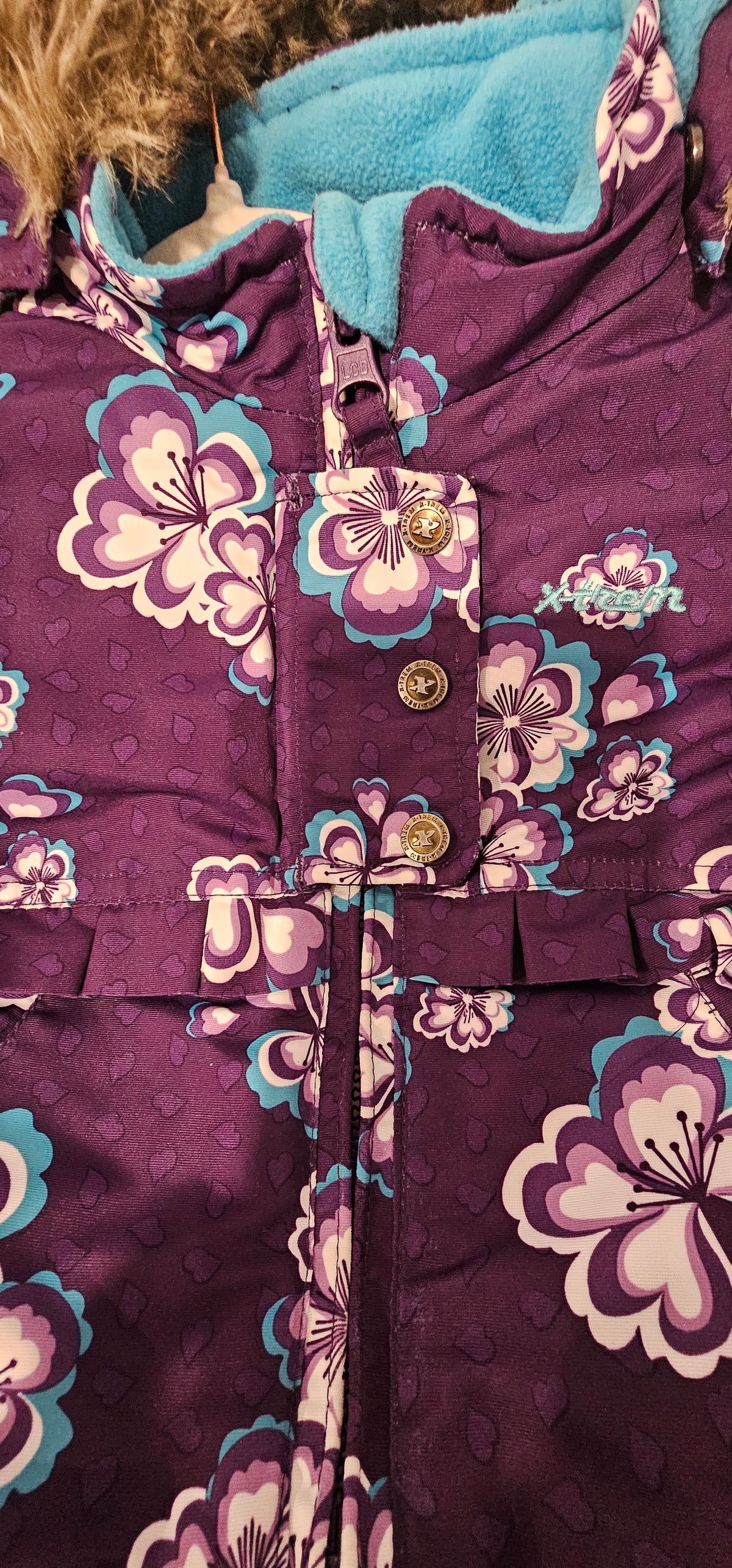 Floral coat zipper and snap-fastened storm flap detail